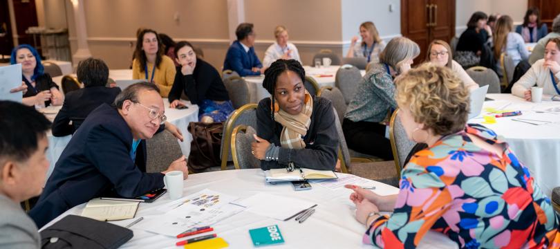 A group of people sitting around a table in discussion at Engage 2024