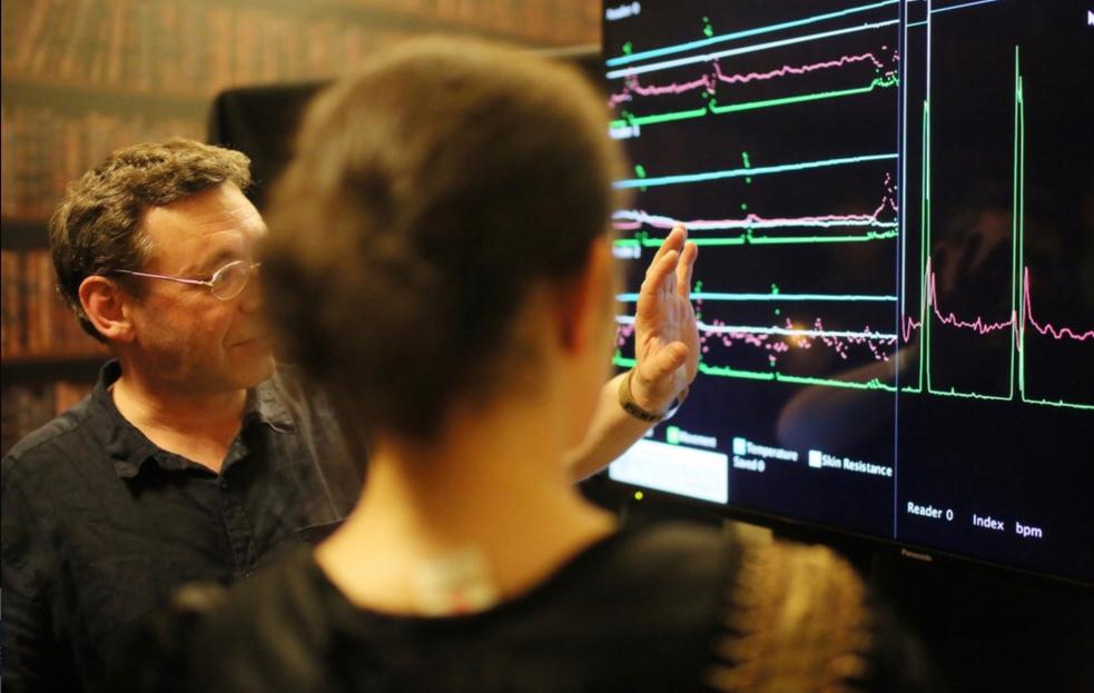 Two people looking at a computer screen with waveforms on