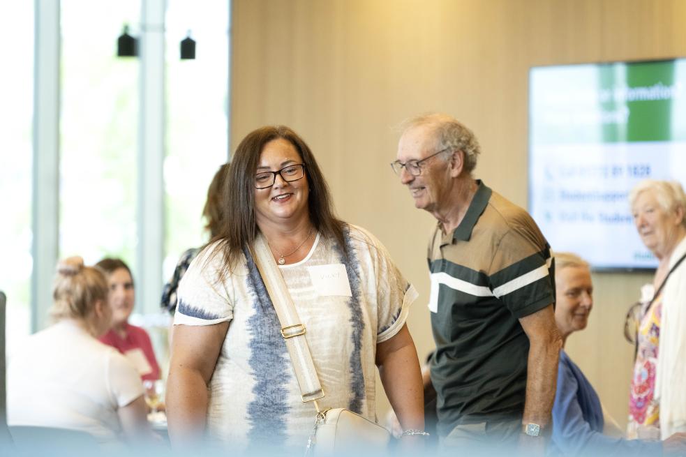 People smiling, taking part in a Community Action Forum event 