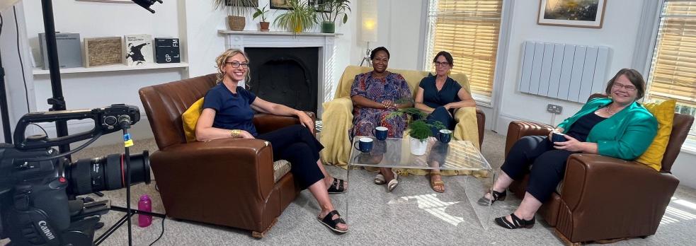 Sophie Duncan, Jude Fransman, Fay Scott, Louise Archer (R-L) sat in armchairs around a coffee table, with filming and sound equipment around them, smiling at the camera