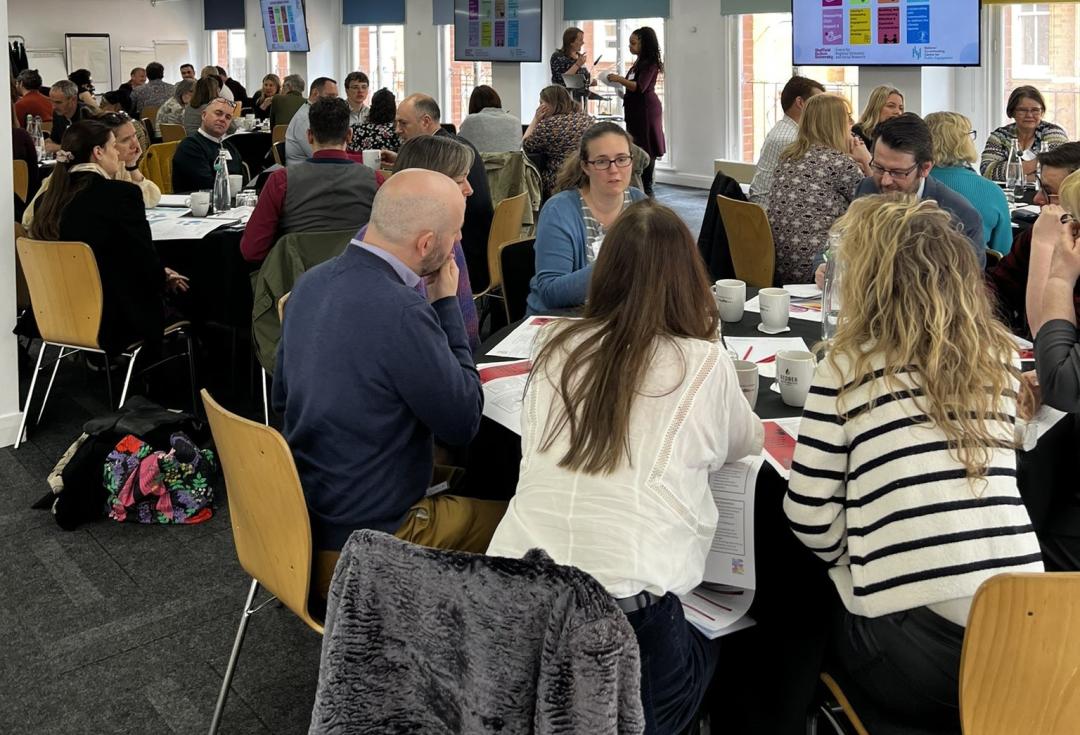 Members of the NCIA action learning groups discussing topics around tables.